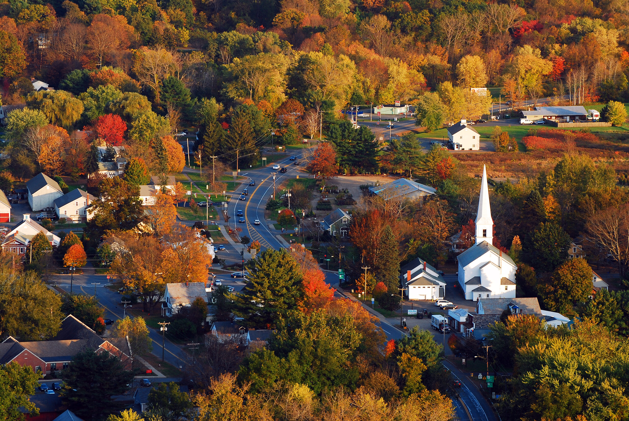 New England town with trees and cars on the road