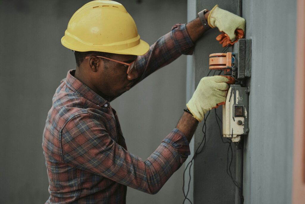 Electrician fixing part of a wall