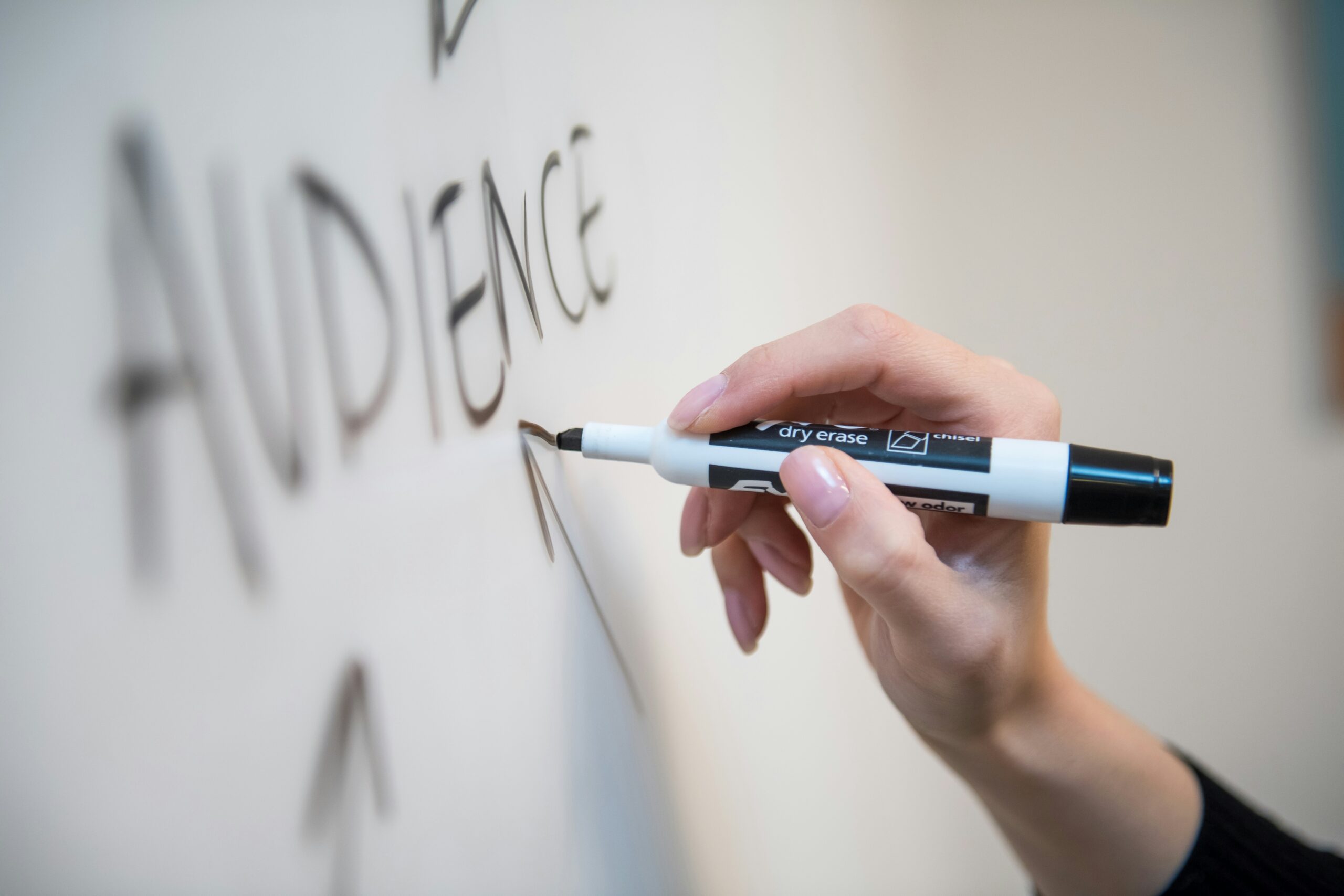 Hand writing with black marker on dry erase board