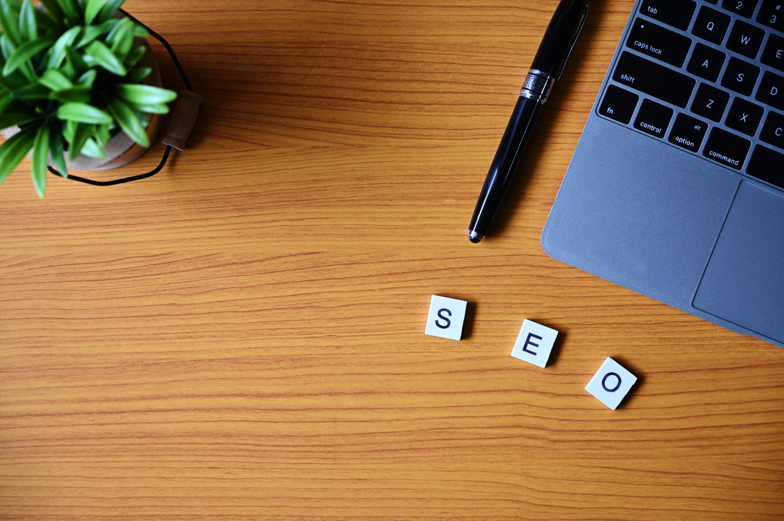 Laptop on desk with SEO letters spelled out