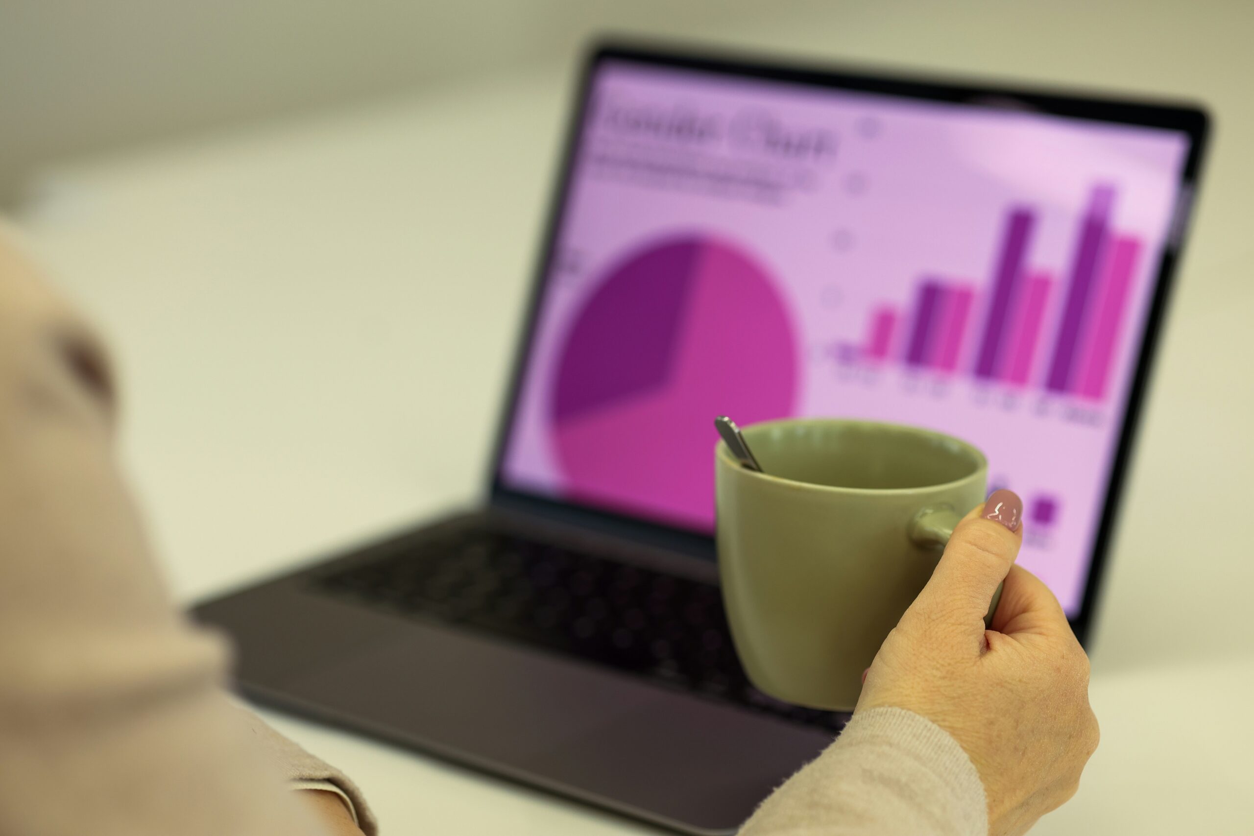 Woman on a laptop looking at a pink pie chart