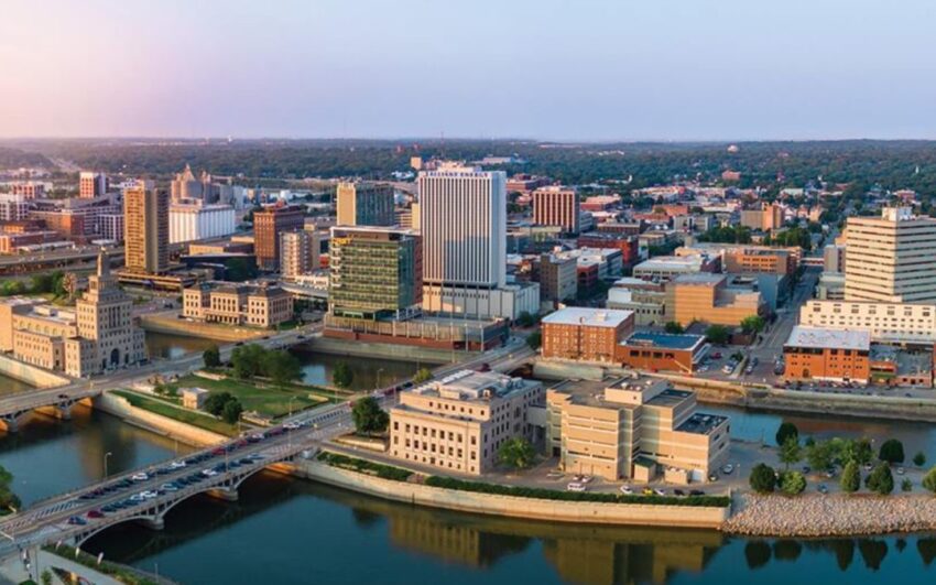 Aerial view of a downtown city skyline with office buildings, bridges, and a river running through the urban area.