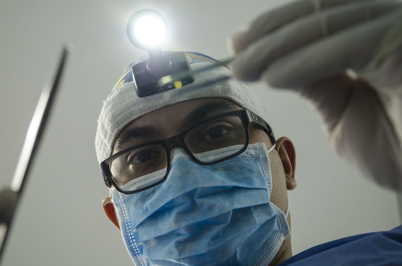 Dentist wearing a mask and headlamp performing a dental examination with tools.