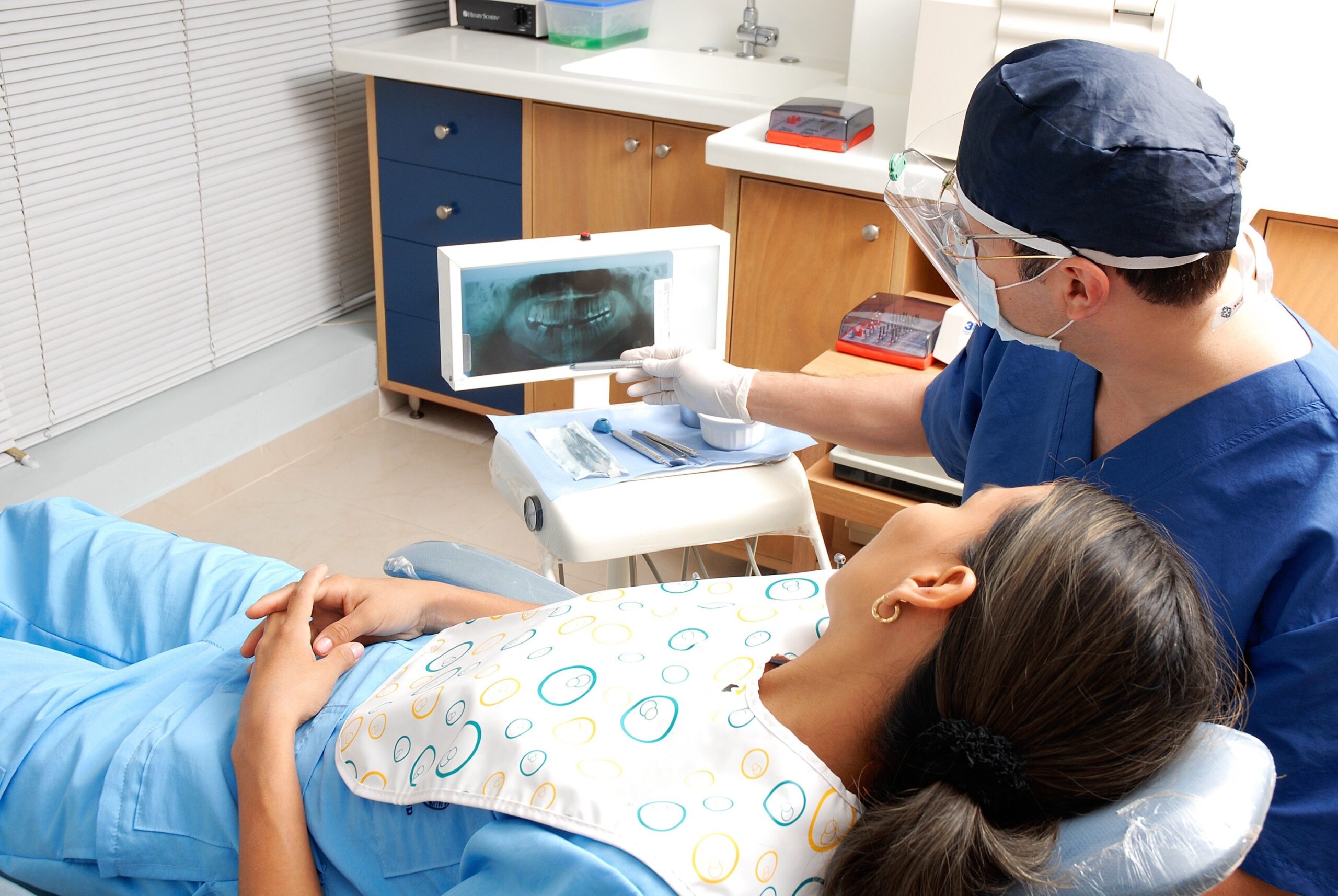 Dentist showing dental X-ray to patient during consultation in clinic