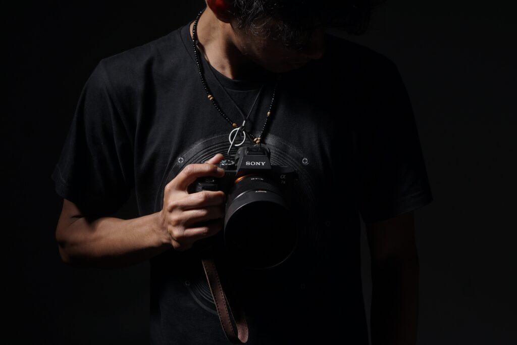 Photographer holding a professional camera in low light setting
