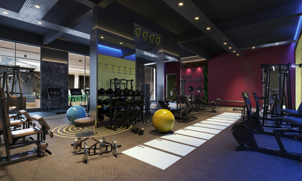 Modern gym interior with weight machines, dumbbells, stability balls, and a numbered turf lane under colorful ambient lighting and a dark ceiling.