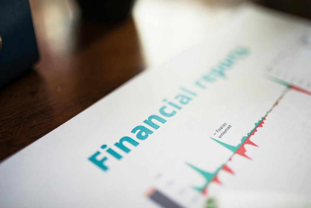 Close-up of a financial report document showing charts and graphs with the word “Financial” in large blue text on a desk.