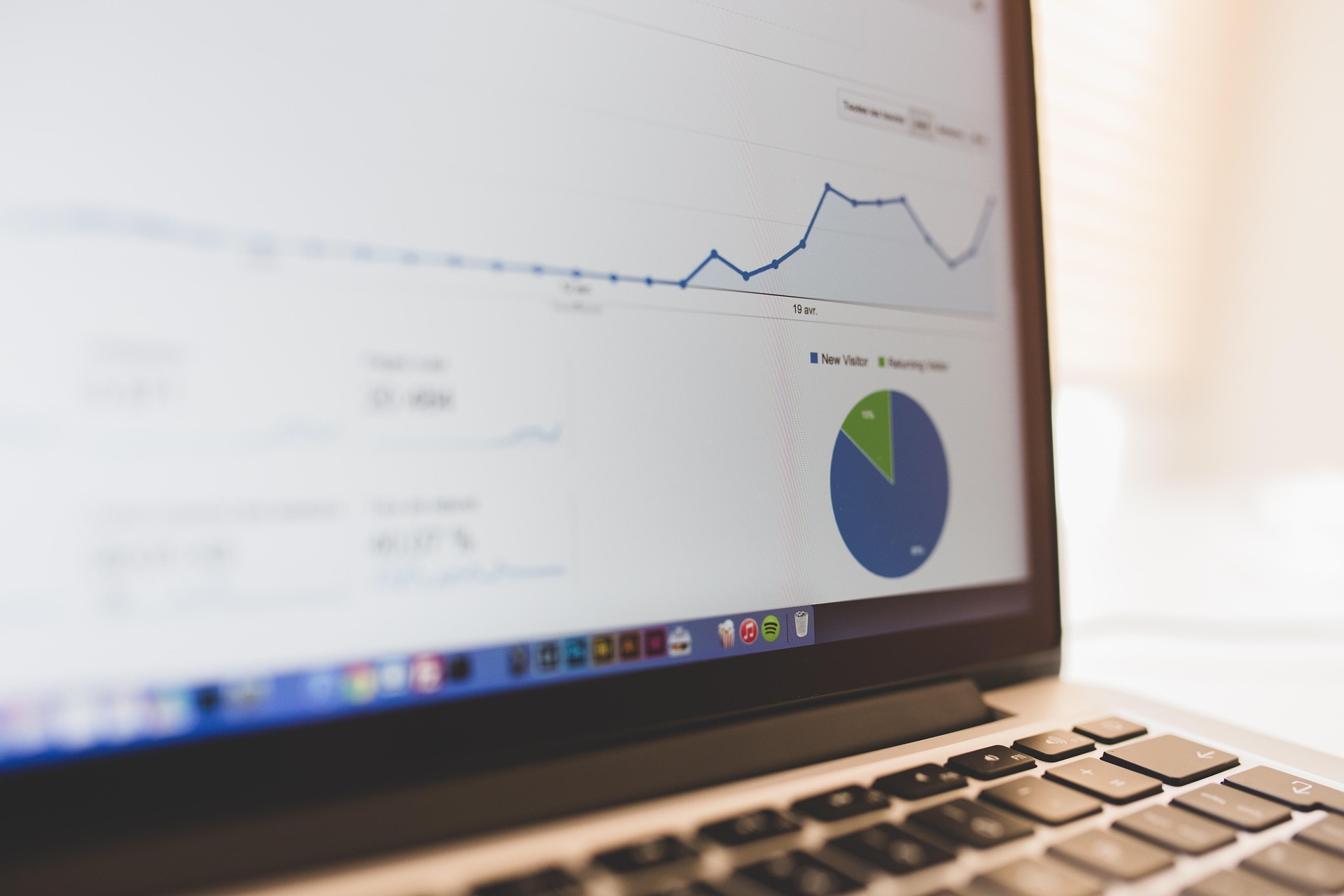 Laptop displaying website analytics with a line graph and pie chart.