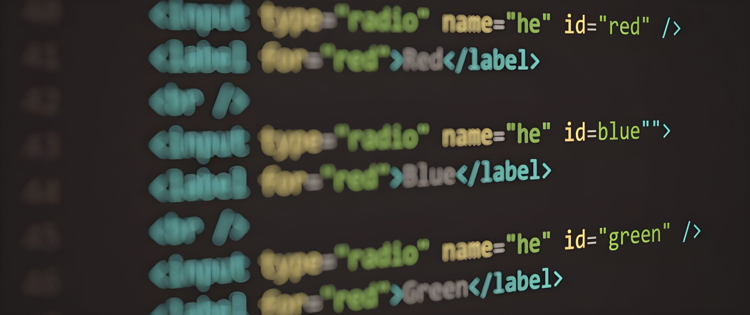 Close-up of colorful HTML code displayed on a dark computer screen, showing label elements with red, blue, and green IDs.