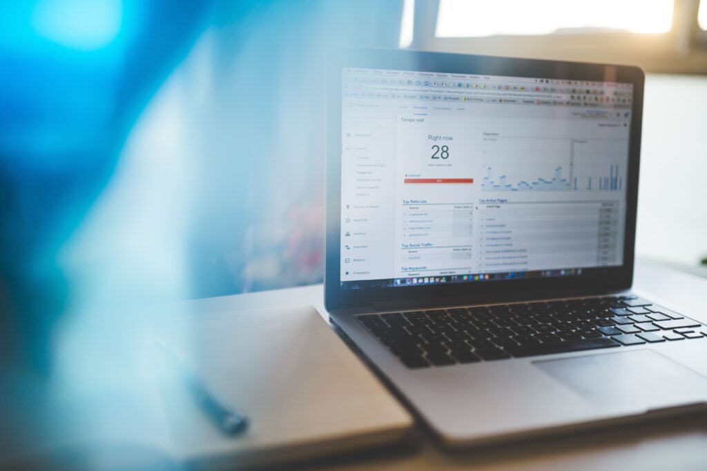 Laptop displaying website analytics and traffic data on a desk in a bright office.