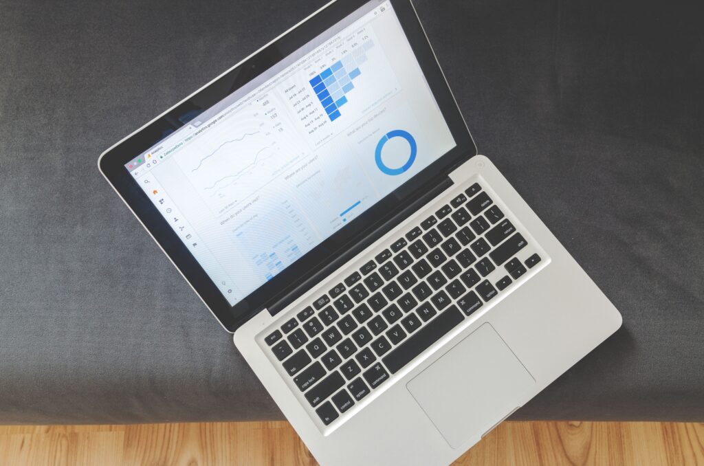 Overhead view of a laptop displaying website analytics charts and visitor data.