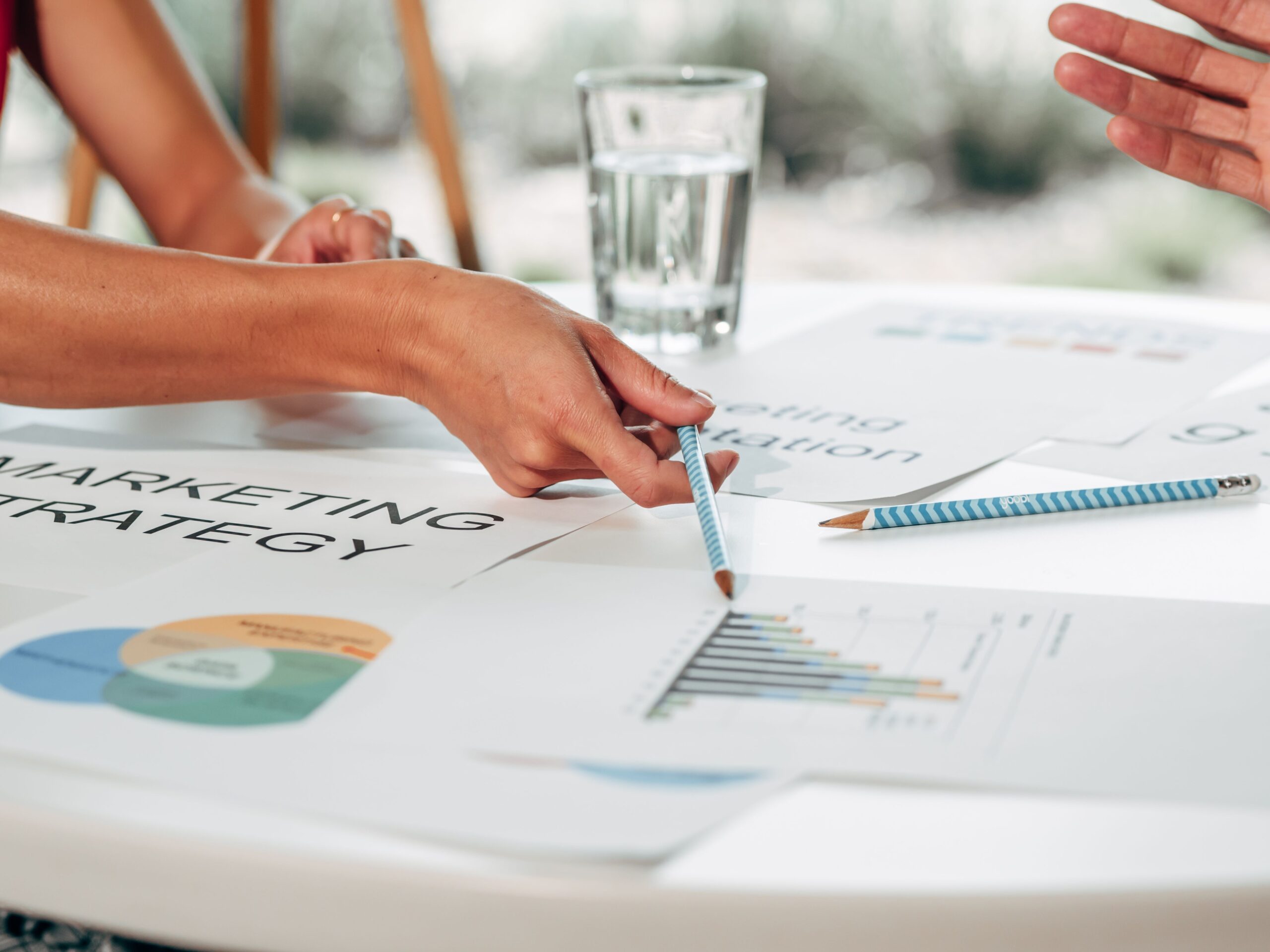 Marketing team discussing strategy while reviewing printed charts and reports.