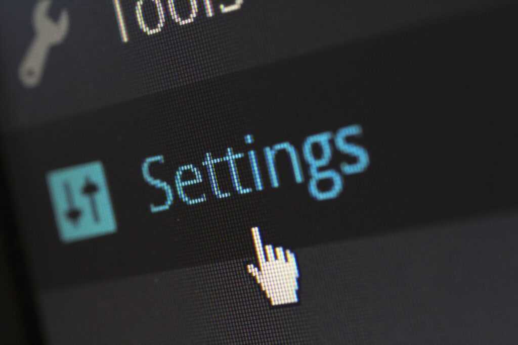 Close-up of a computer screen showing a cursor selecting the Settings menu.