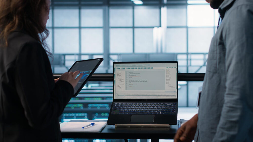 Two people discussing and looking at their devices