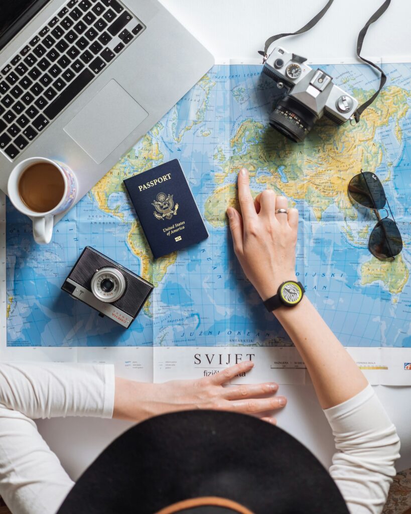 Laptop on a desk beside a world map used to plan global expansion